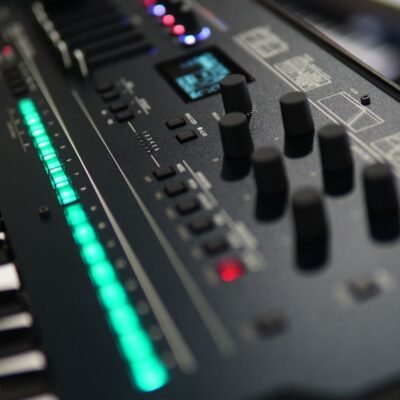 Close-up of a professional audio mixer with LED indicators and control knobs, showcasing musical technology.